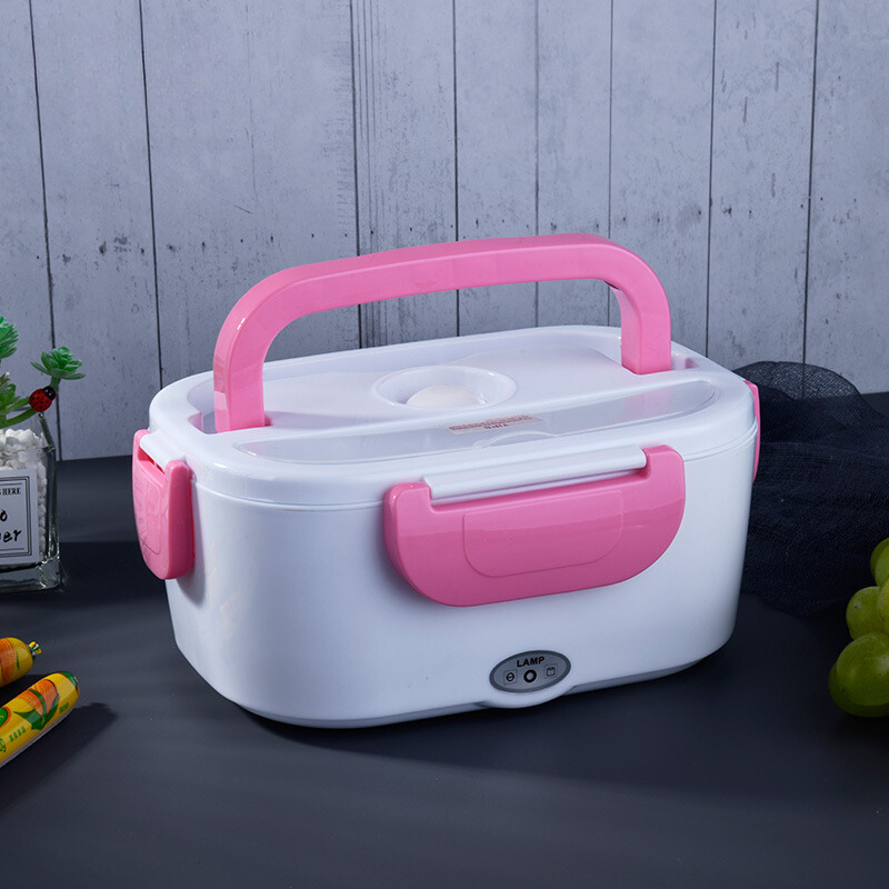 White and pink electric lunch box on a dark surface with a light gray wooden background