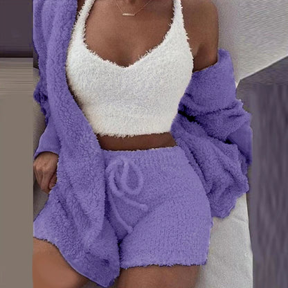 Person wearing a white fuzzy top and purple fuzzy shorts with a matching cardigan.