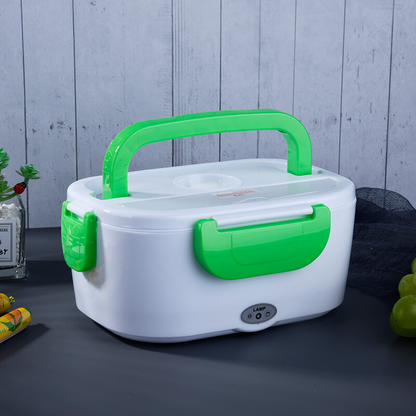 White and green electric lunch box on a dark surface with a light gray wooden background