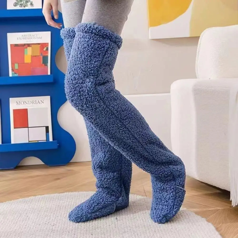 Person wearing blue fuzzy knee-high socks in a living room setting.