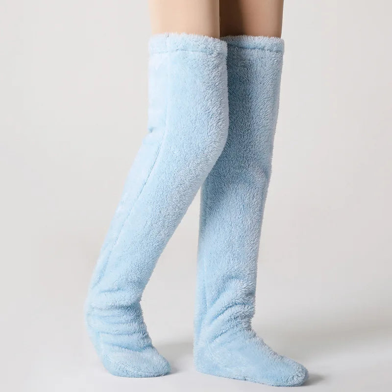 Light blue fuzzy socks worn by a person on a plain background