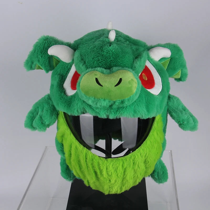 Green plush toy with red eyes and white horns on a white background