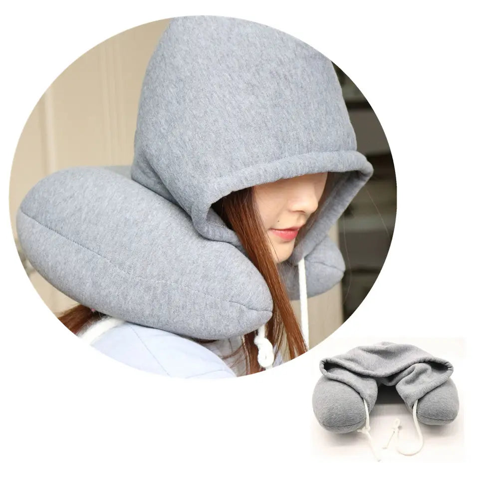 Gray hooded travel pillow worn by a person with a blurred background