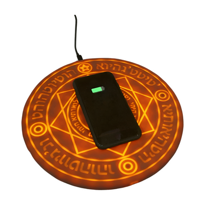 Wireless charging pad with a phone on top, featuring mystical symbols.