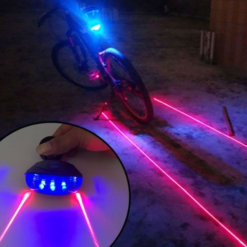 Bicycle with laser lights on a dark surface, showing close-up of laser device.