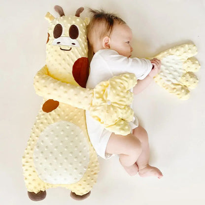 Baby lying on a white surface with a giraffe-shaped plush toy