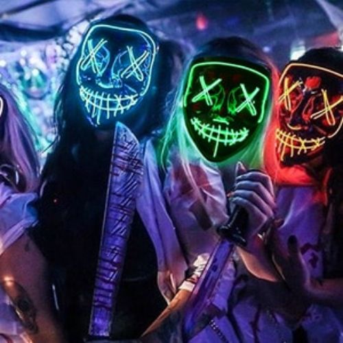 People wearing colorful LED masks in a dark setting