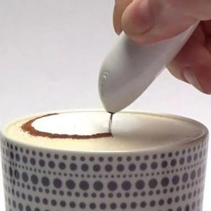 Hand using a white handheld device to pour a dark liquid into a polka dot cup.