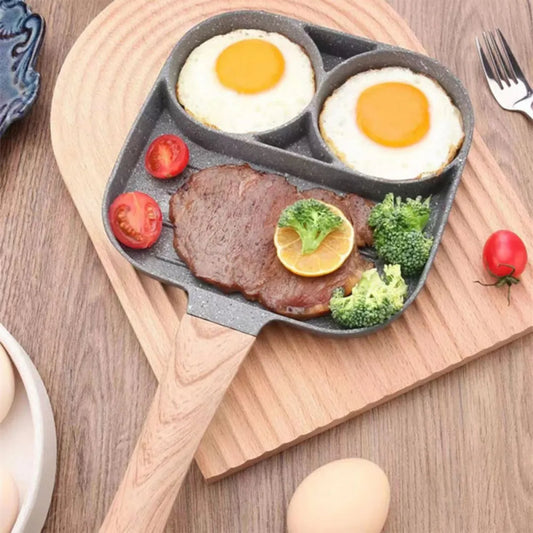 Heart-shaped frying pan with eggs, steak, and vegetables on a wooden surface
