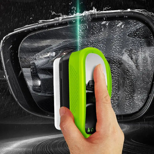 Hand using a green car window cleaning tool on a car's side mirror.