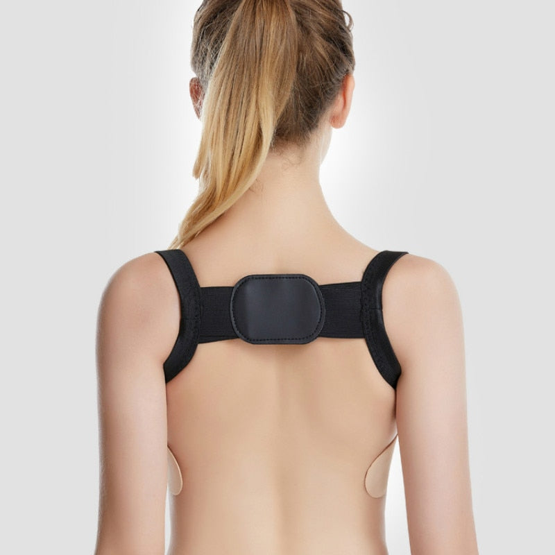 Person wearing a black posture corrector on a plain background