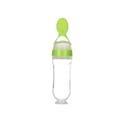 Clear baby bottle with green cap and handle on a white background