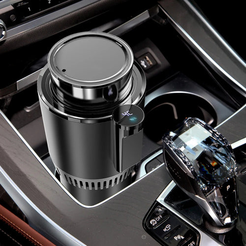 Car cup holder with a black cylindrical device and a transparent car air freshener.
