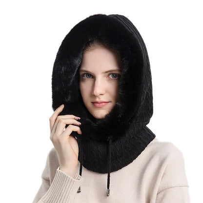 Person wearing a black knitted hood with fur trim on a white background