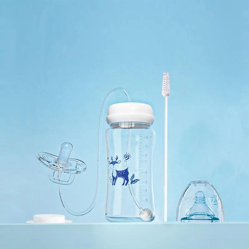 Clear baby bottle with accessories on a light blue background