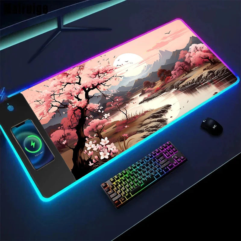 Gaming desk setup with a large mouse pad featuring a cherry blossom design, keyboard, and phone.