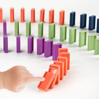 Colorful dominoes set with a hand pushing one of them, on a white background