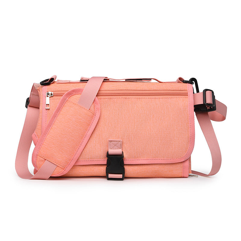 Pink messenger bag with black straps on a white background
