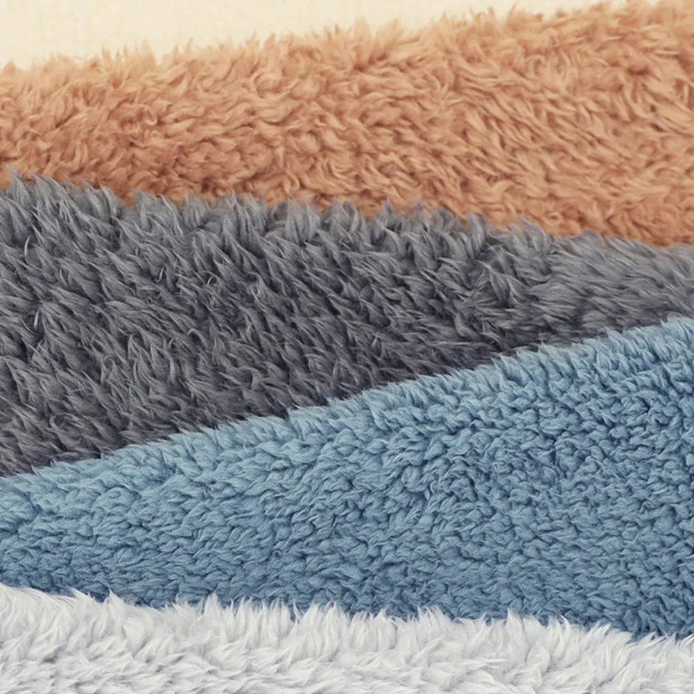 Stack of textured bath mats in brown, gray, blue, and white.