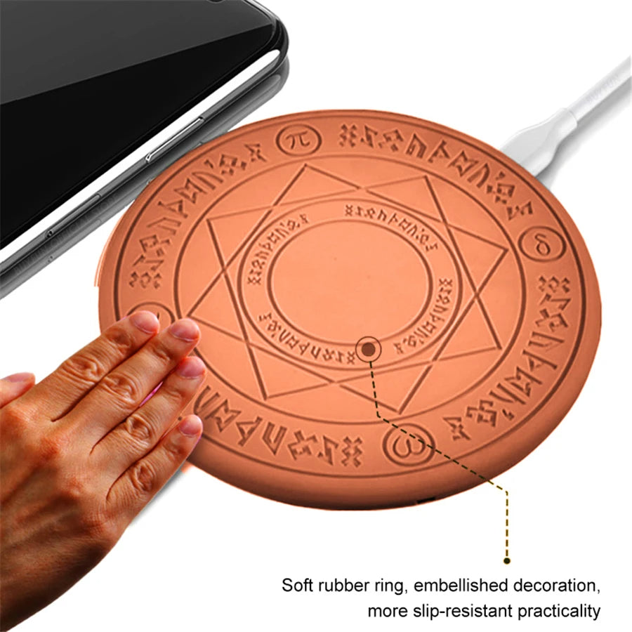 Round rubber mat with engraved design, held by a hand, next to a smartphone and cable.