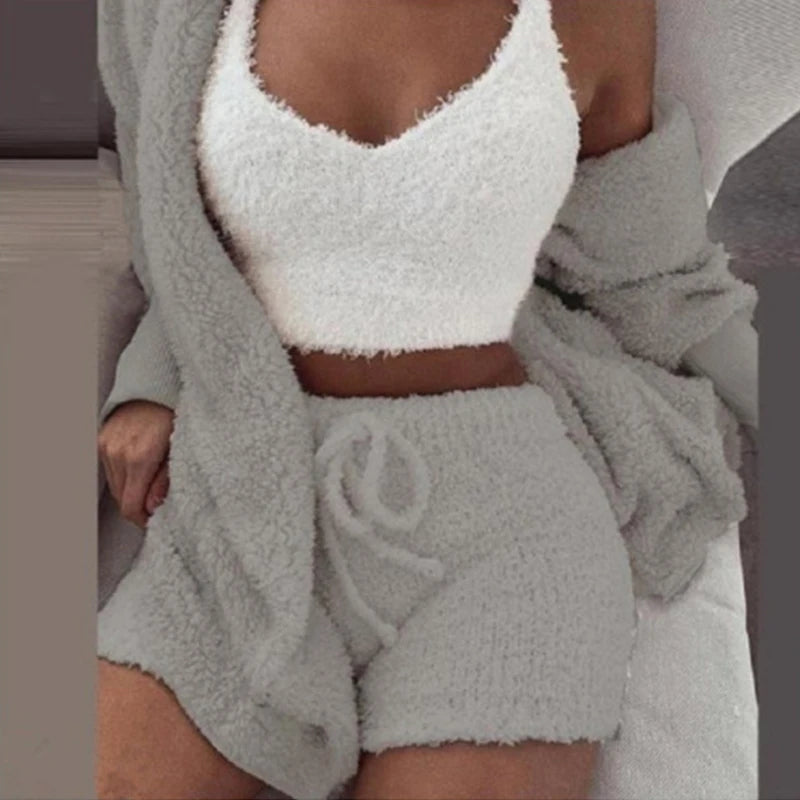 Person wearing a white fuzzy top and gray shorts with a matching robe.